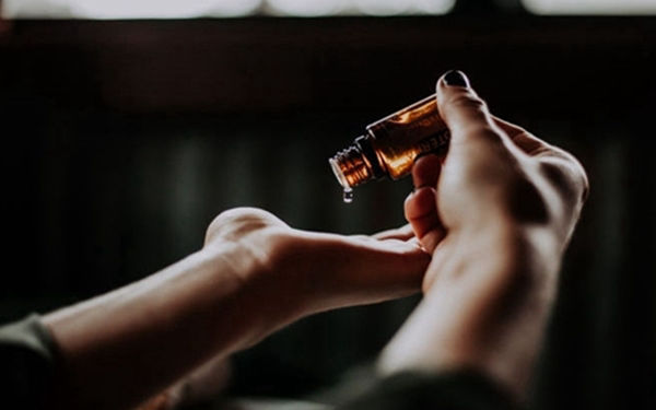 Oil being poured into the palm of a hand